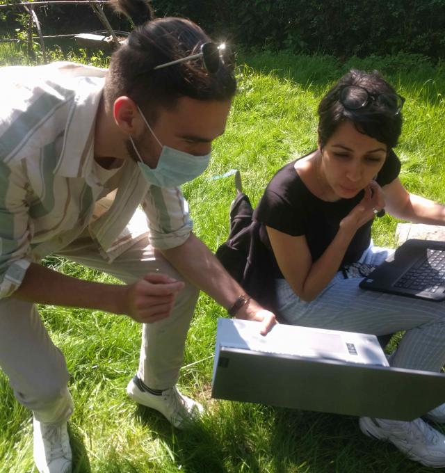 onderzoekswerking - 2 mensen met computers in een tuin